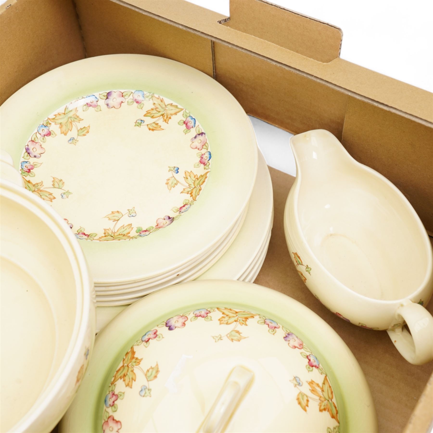 Clarice Cliff part dinner service, decorated with floral sprigs, including two covered tureens, six dinner plates, serving platter etc