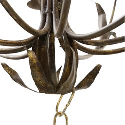 Early 20th century wrought iron and gilt metal twelve-light candle chandelier, with scrolling branches, stylised leaf decoration and chain suspension