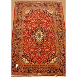  Kashan red ground rug, floral field, repeating border, signed by the weaver, 218cm x 142cm  