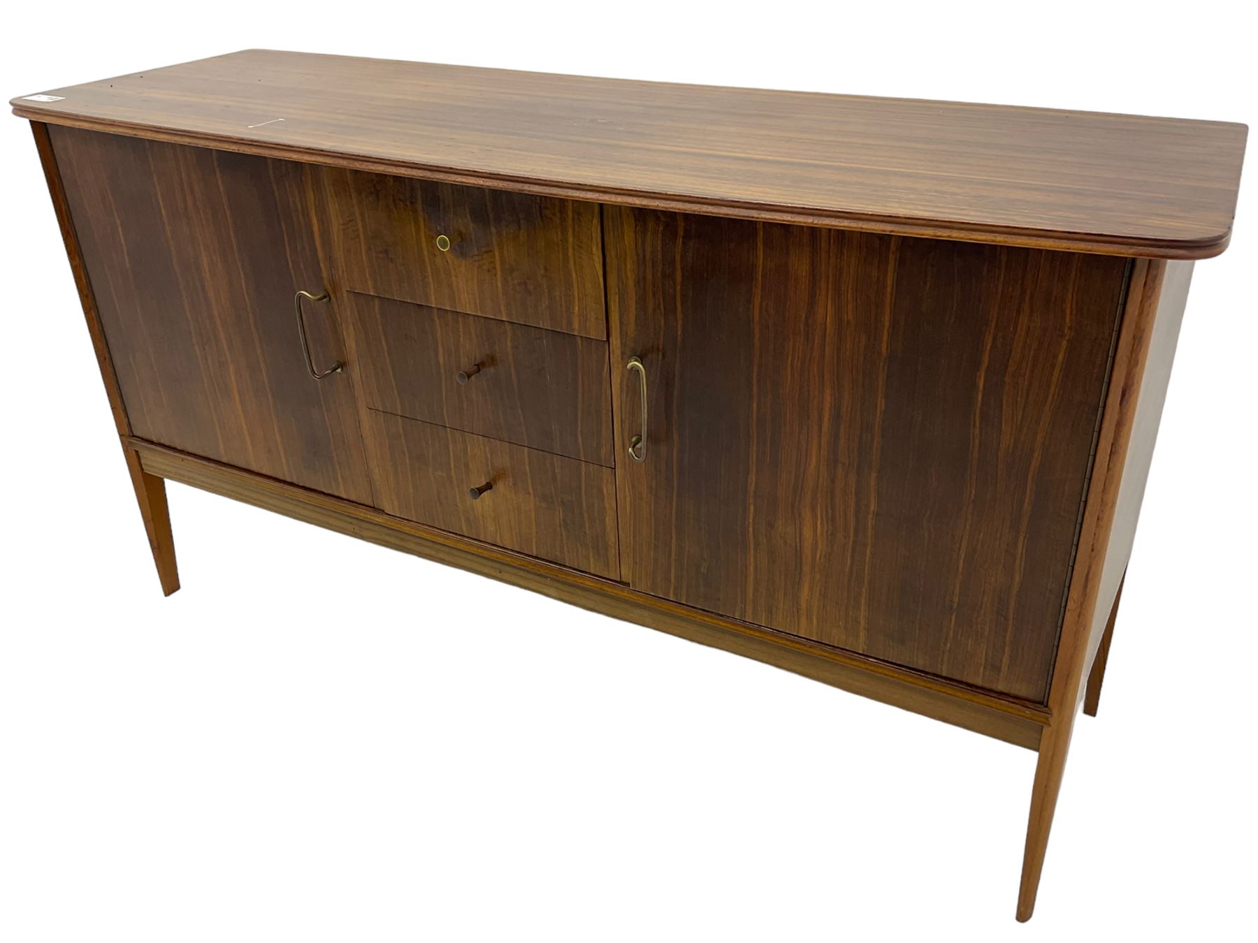 Peter Hayward for Vanson - mid-20th century teak sideboard, rectangular top with rounded corners over three central drawers, flanked by two cupboard doors enclosing shelves, raised on tapered supports
