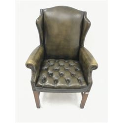 Georgian style wing back armchair upholstered in deep buttoned and studded green leather, square supports