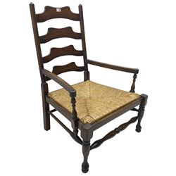 Georgian design oak country low armchair, waived ladder back over rush seat, raised on turned  supports united by stretchers; together with matching stool