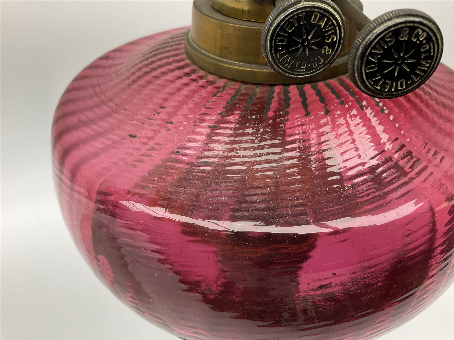 Victorian table standing oil lamp, brass fittings, cranberry glass reservoir, brass column on black enamelled ceramic base, with a frosted glass shade and clear glass chimney, H68cm