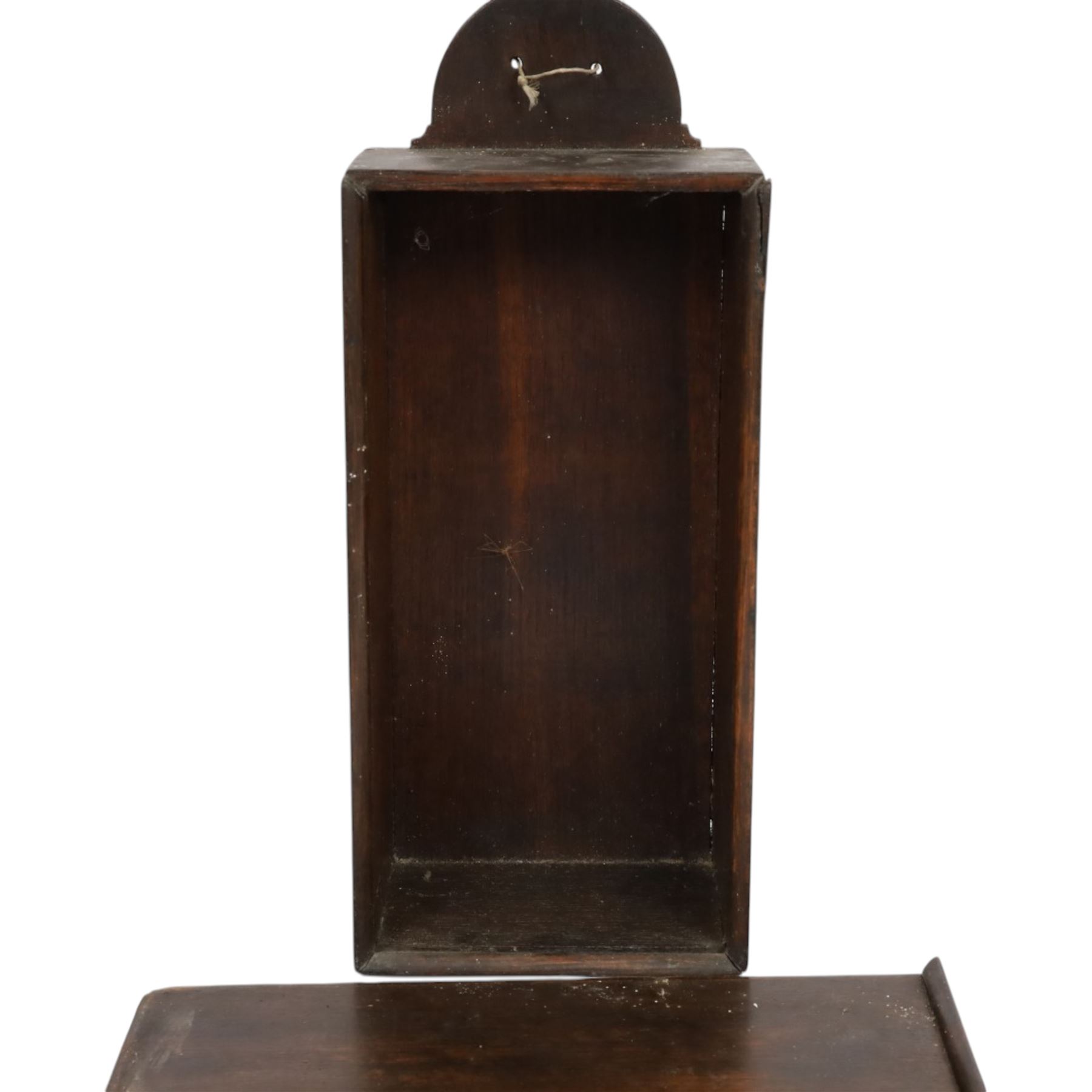 Three George III and later oak candle boxes, the first example of tapering form with shaped and pierced scroll crest, above a hinged lid, H50.5cm W18cm D13cm, the second of plain rectangular form with tapering crest, above a studded leather hinged sloped lid, H46cm W15.5cm D15.5cm, and third of plain rectangular form with demi-lune crest, with lift up front, H42.5cm W17.5cm D12cm 
