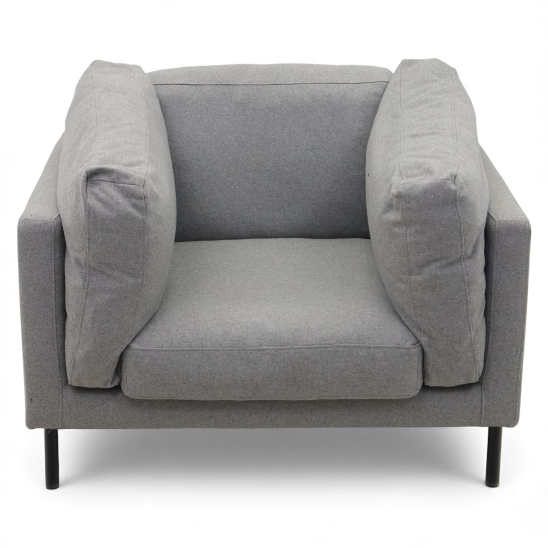 Modern snuggler armchair, upholstered in grey fabric, box-shaped frame with loose back and side cushions, raised on slender black metal legs