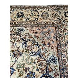 Persian Kashan ivory ground carpet, floral design central medallion surrounded by trailing and interlaced leafy branches with palmettes and flower heads, matching patterned border with guard stripes 