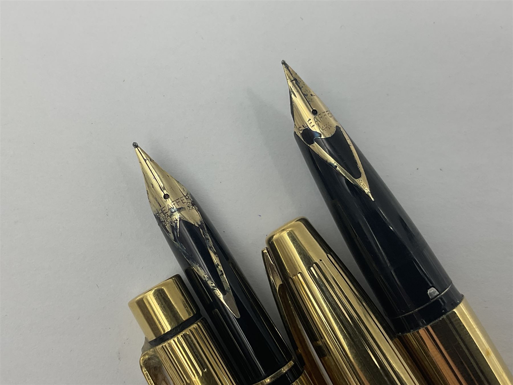 Sheaffer Triumph Imperial fountain pen, the gold plated barrel with fluted stripe design and gold nib stamped 14K 585, together with a Sheaffer Targa slimline fountain pen with gold plated barrel similarly decorated with gold nib stamped 14K 585, ballpoint pen and propelling pencil, each with a fluted gold plated barrel, largest L13.5cm (4)