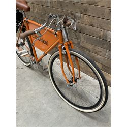 Fully restored vintage advertising bicycle with 2 stroke petrol engine, orange frame, tan leather seat