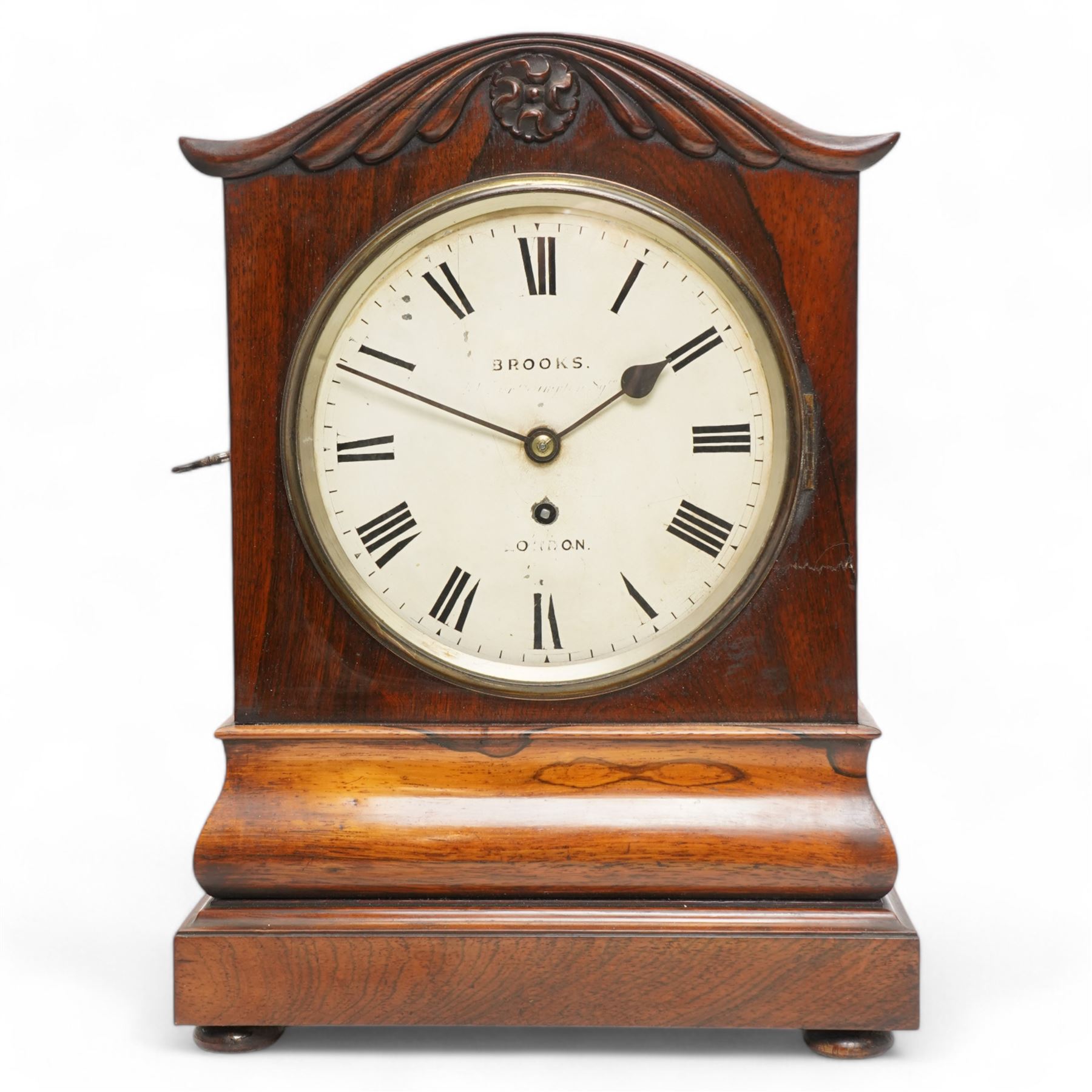 Brooks of London- Regency 8-day rosewood bracket clock c1825, with a serpentine shaped pediment and foliate carving on an ogee stepped base with bun feet, 8