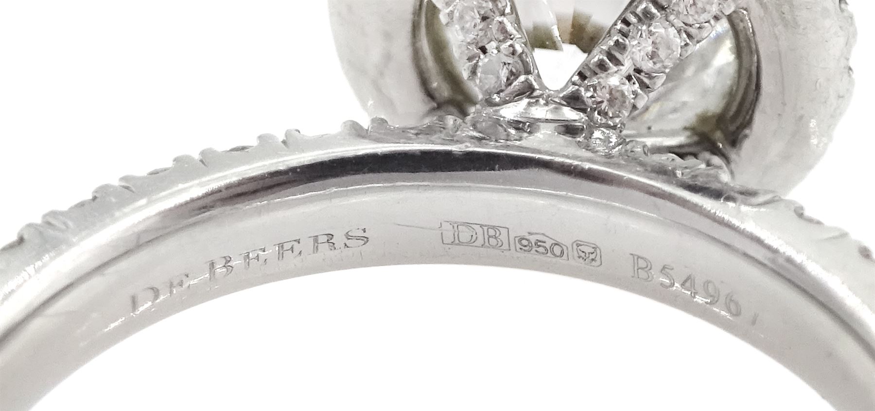 De Beers Aura platinum round brilliant diamond ring, the central diamond solitaire of 1.07 carat, clarity VVS2, colour E, with GIA certificate, surrounded by halo of diamonds and diamond set shoulders, total diamond weight 1.46 carat boxed with authenticity card and purchase receipt dated 2017