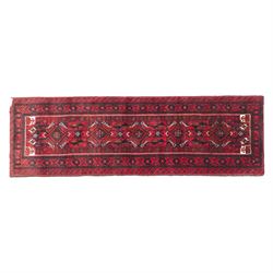 North east Persian Baluch hand-knotted runner, crimson ground with a vertical column of ho...
