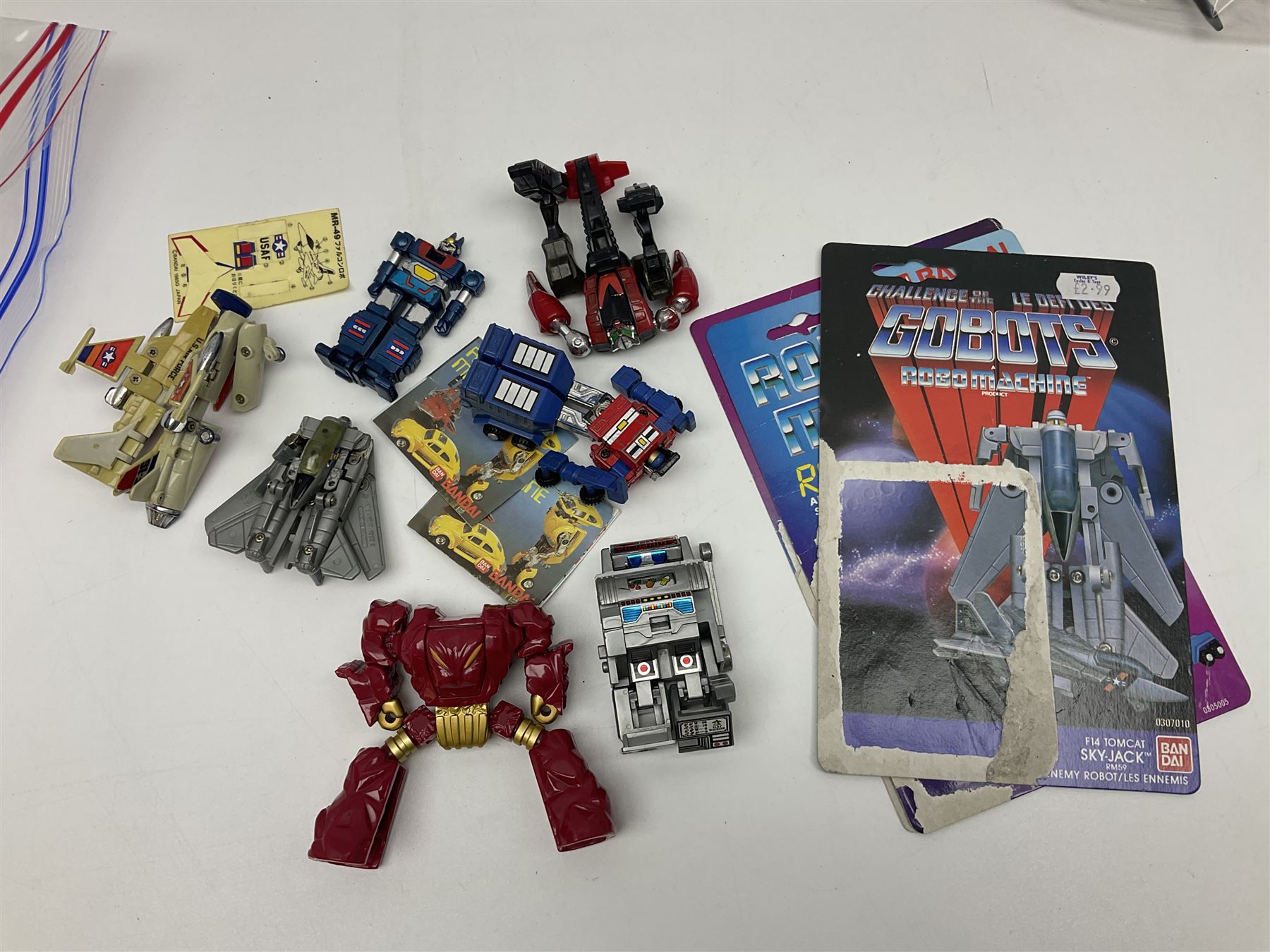 Four 1980sTransformer G1 - Optimus Prime 1984; DinoBot Sludge (Diplodocus) 1984; Cyclonus 1986; and Runamuck 1986; with paperwork; seven Bandai Robo Machines Robots/Transformers; almost fully stocked Panini Sticker album; two annuals; three comics; two posters; and Ladybird story book