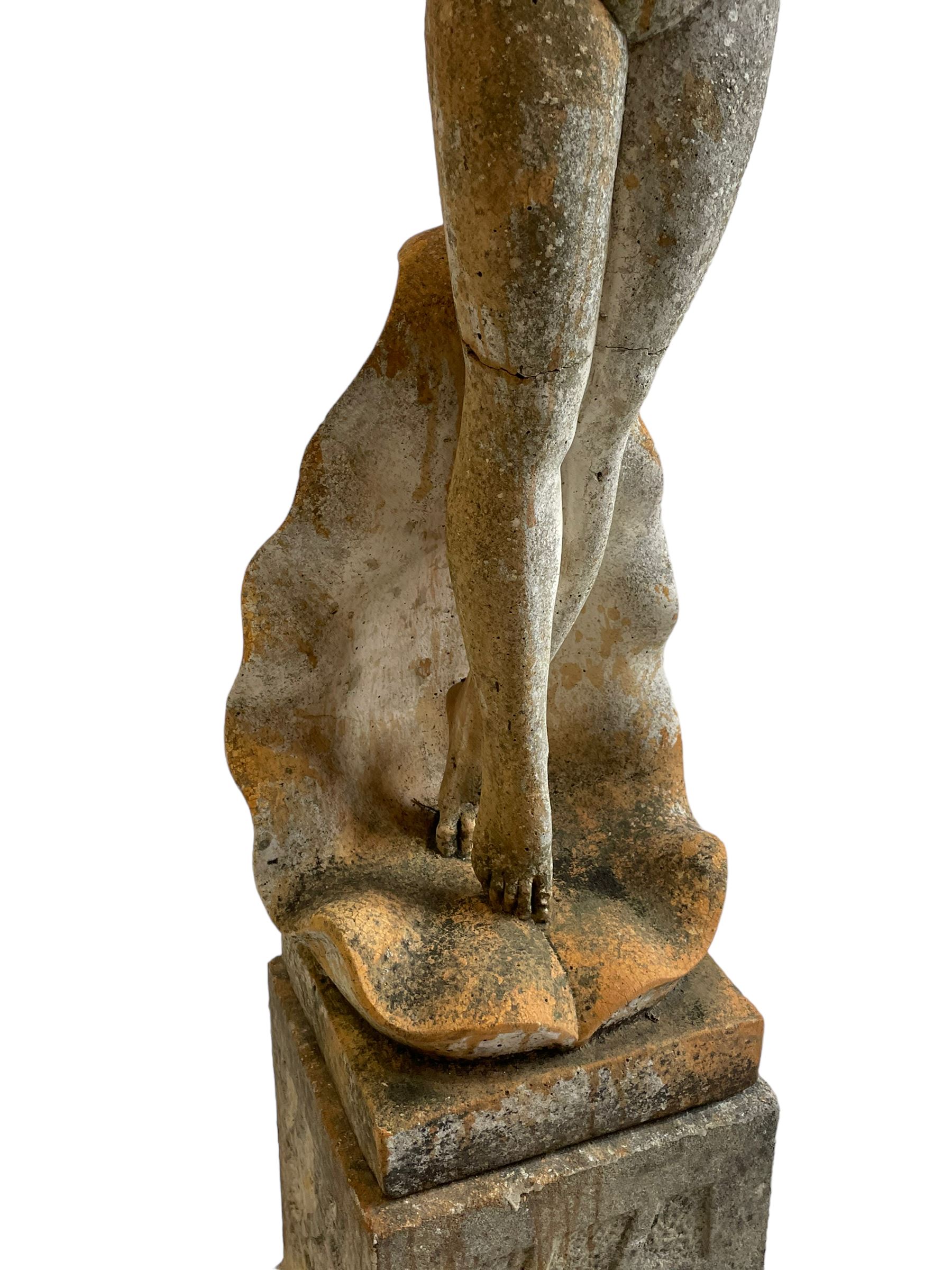 Cast stone two-piece garden figure of the Birth of Venus, depicting the goddess emerging from a stylised shell, on square base with stepped moulded plinth 