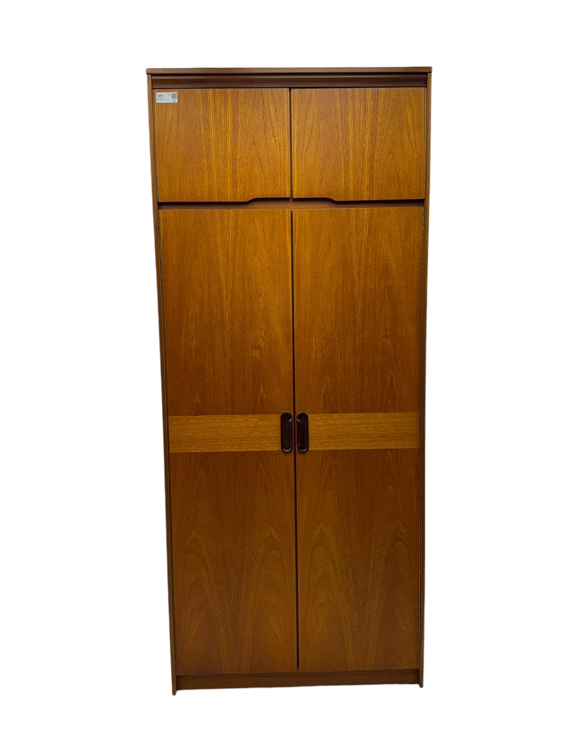 William Lawrence - mid-20th century teak double wardrobe, upper storage section over twin doors featuring recessed handles and contrasting horizontal panel, enclosing a hanging rail compartment, on plinth base with concealed castors