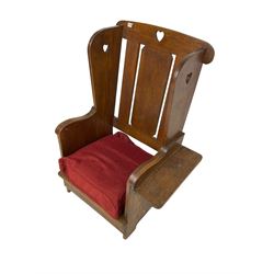 Arts and Crafts design oak reading wingback armchair, high back with pierced heart design, drop-leaf side table to one arm