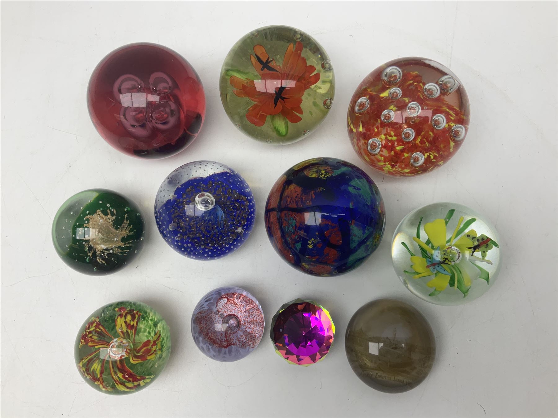 Collection of glass paperweights, to includes examples with internal air bubble inclusions and ones with internal flowers (11)