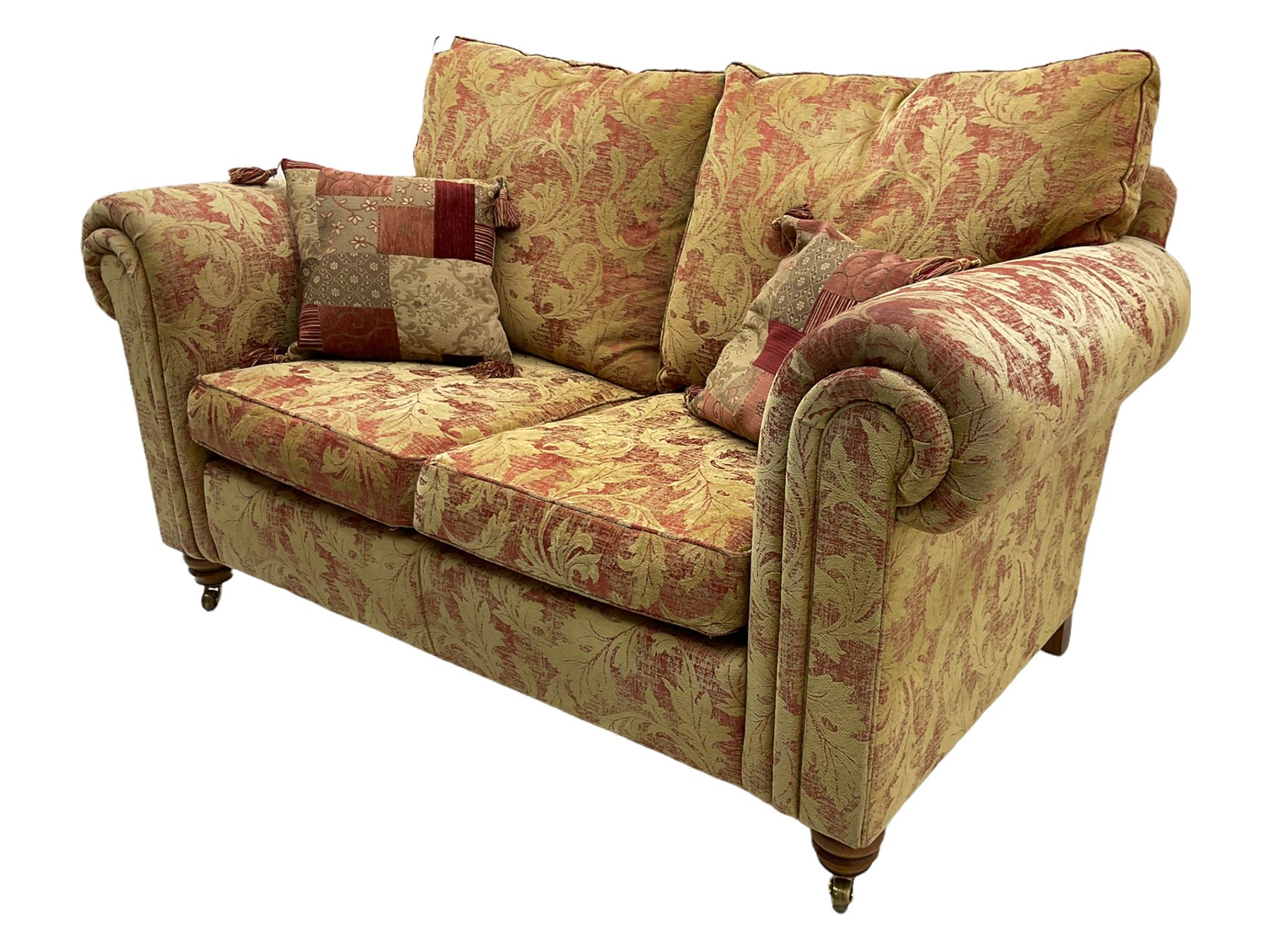 Duresta two seat sofa, upholstered in pale gold and rose fabric, mahogany feet; and matching rectangular footstool