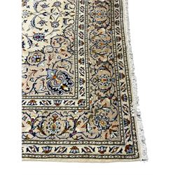 Persian Kashan ivory ground carpet, decorated all-over with interlacing foliate and stylised plant motifs, central scrolling medallion and matching spandrels, the guarded border decorated with repeating palmettes
