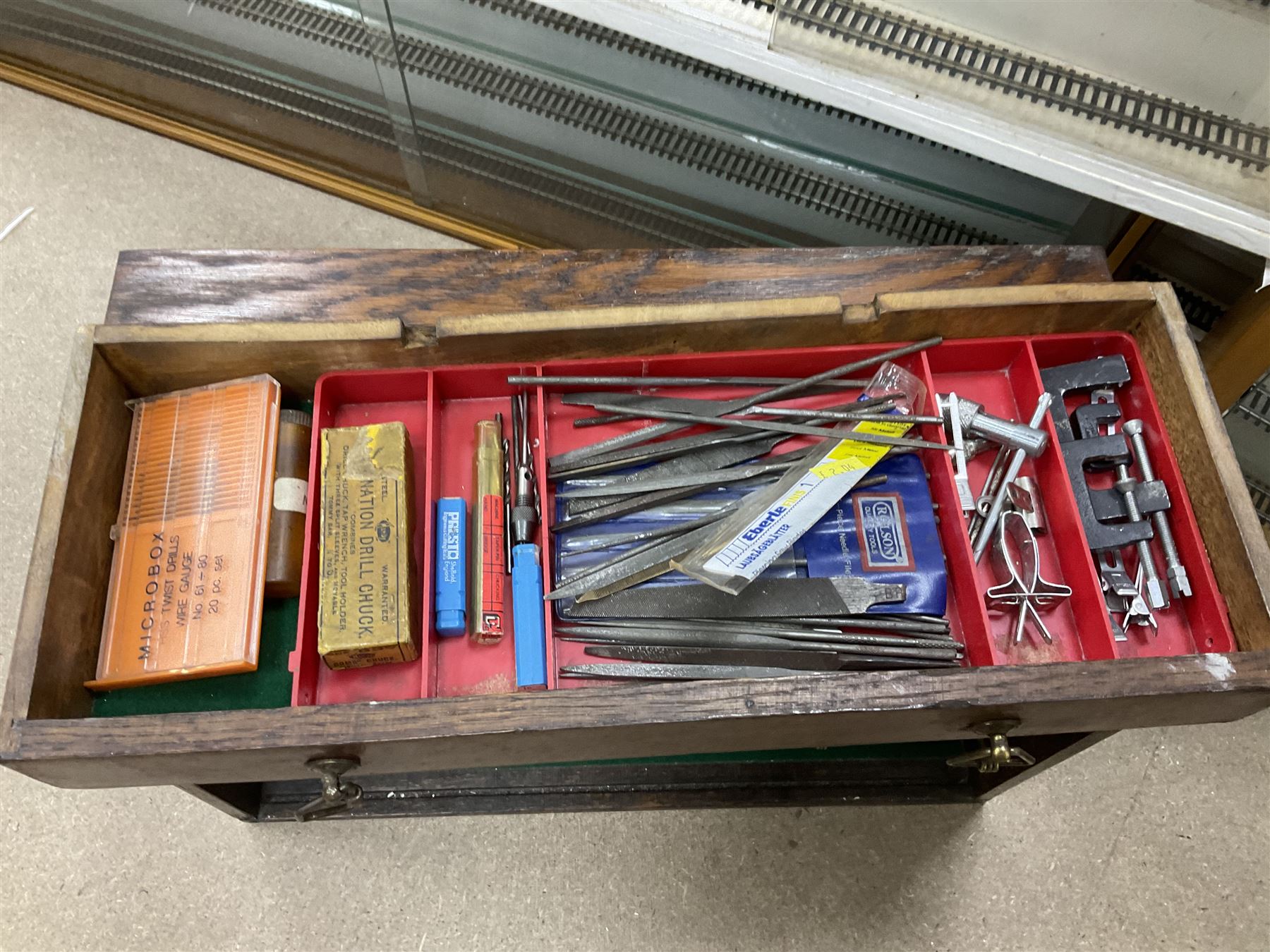 Six shelved cabinets for displaying ‘00’ gauge locomotives comprising plain plywood and white painted examples with track applied to various shelves, largest H63cm, W107cm, D27cm; Collection of tools for building model locomotives to include Weller PU-2D Soldering Pencil and Standard Tip Soldering Iron 20W/230V, Humbrol Modellers Airbrush, Power Supply Units and two wooden chests one of which housing a collection of tools including tweezers, scalping tools, wrenches etc 
