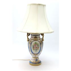 A Sevres style table lamp, of baluster form with twin gilt scroll handles, the body decorated with hand painted flowers contained within blue borders, and heightened in gilt, with cream fabric shade, overall H62cm.