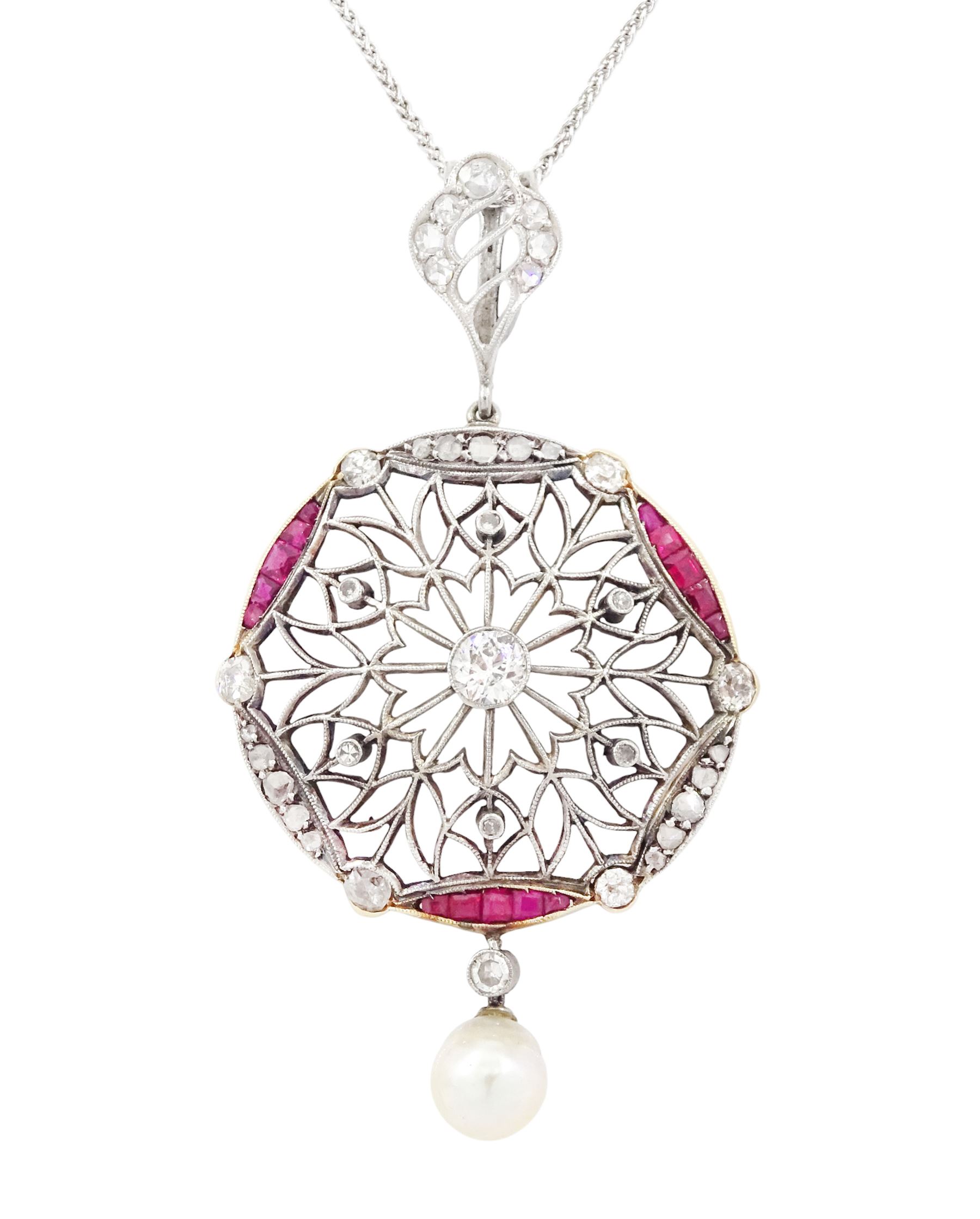 Early 20th century platinum and 18ct yellow gold ruby and diamond circular pendant, single old cut diamond of approx 0.25 carat, within a milgrain pierced fancy foliate surround, set with single cut diamonds, to a navette shaped border set with alternate calibre cut rubies and rose cut diamonds, each spaced by a single old cut diamond, suspending a pearl and diamond drop, on a later 18ct white gold wheat link chain necklace, hallmarked