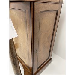 Early Victorian figured mahogany dressing cabinet, the raised shell and scroll carved back lifts to reveal rectangular easel mirror with mahogany band, flat rectangular top with tooled leather inset, slide at each side with matching leather inset, full width drawer above cupboard enclosing a series of five drawers, turned front supports, panelled front, sides and back