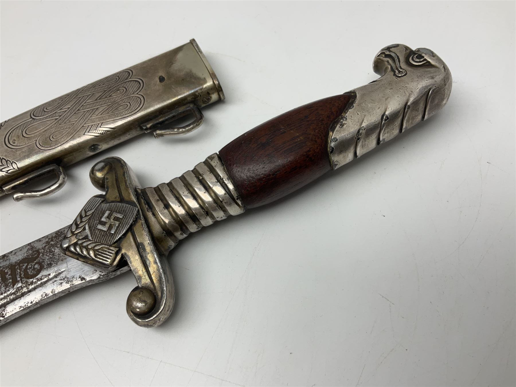 WW2 German RAD (Reichsarbeitdienst) Leader's hewer dagger,  the 25.5cm fullered steel blade engraved Arbeit Adelt (Work Enables) with Eickhorn squirrel maker's mark; scrolling cross-piece, mahogany grip and eagle pommel; in decorative plated scabbard L40cm overall.
