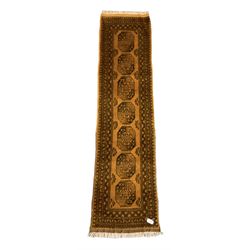 Afghan Bokhara gold ground runner, decorated with seven Gul medallions, six band border with repeating geometric pattern