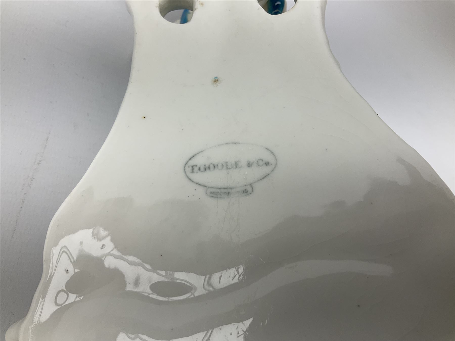 Victorian wall pocket by Moore Brothers retailed by T.Goode modelled as a semi nude white glaze cherub with turquoise ribbon, with encrusted floral decoration, the reverse stamped ‘T.Goode & Co.’, H32cm