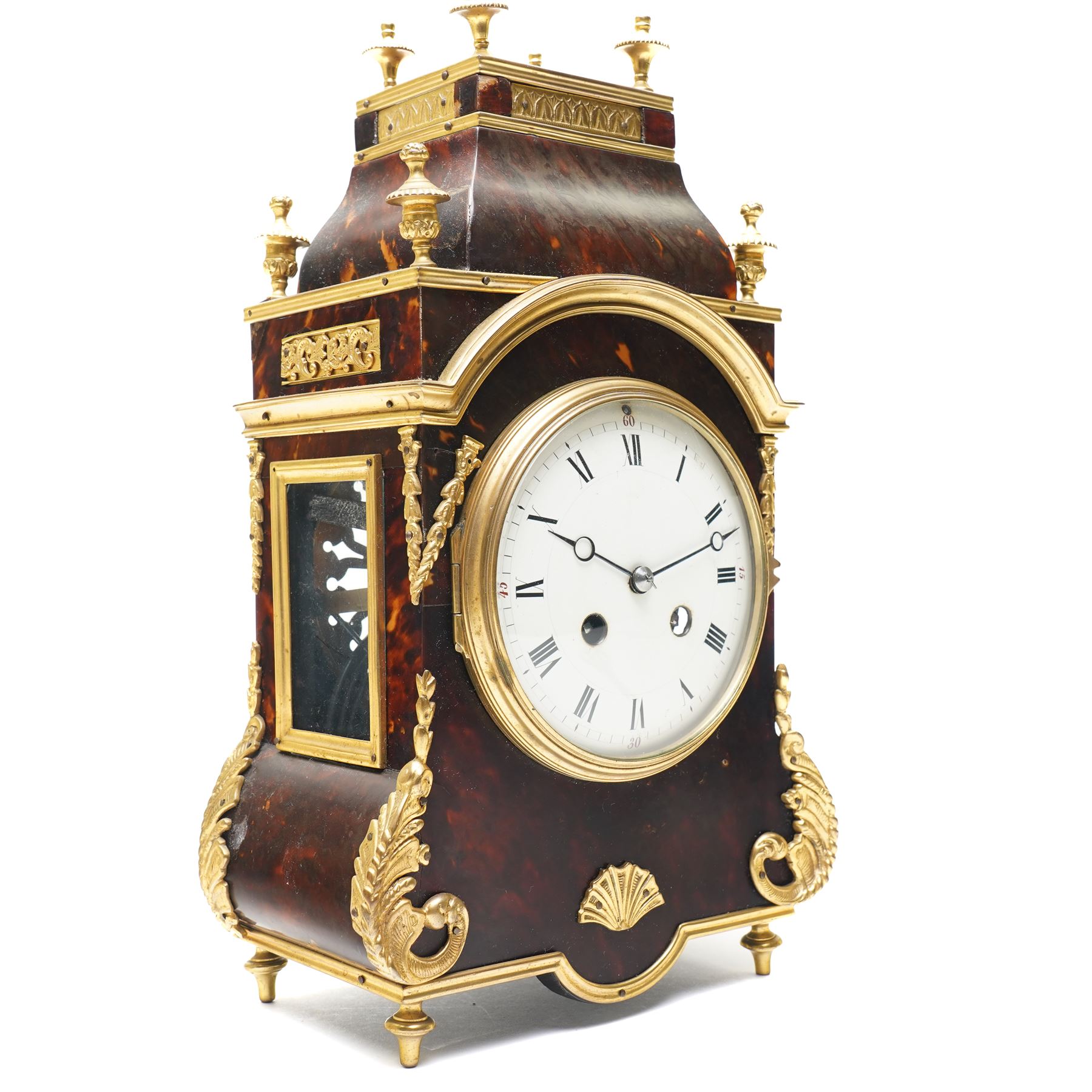 French-late 19th century brown stained 8-day faux Tortoise shell and ormolu mounted mantle clock, rectangular case with glazed side panels and shaped pediment with matching finials, convex enamel dial with Roman numerals, minute track and steel moon hands within a cast brass glazed dial bezel,
twin barrel movement with rack striking, striking the hours and half hour on a coiled gong. With pendulum and key.