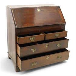 Georgian oak bureau, fall front with pierced brass escutcheon and handles, revealing a fitted interior, above two short over two long drawers, raised on bracket feet