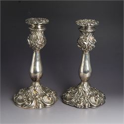 Pair of late Victorian silver candlesticks, each embossed wth floral, foliate and scrollin...