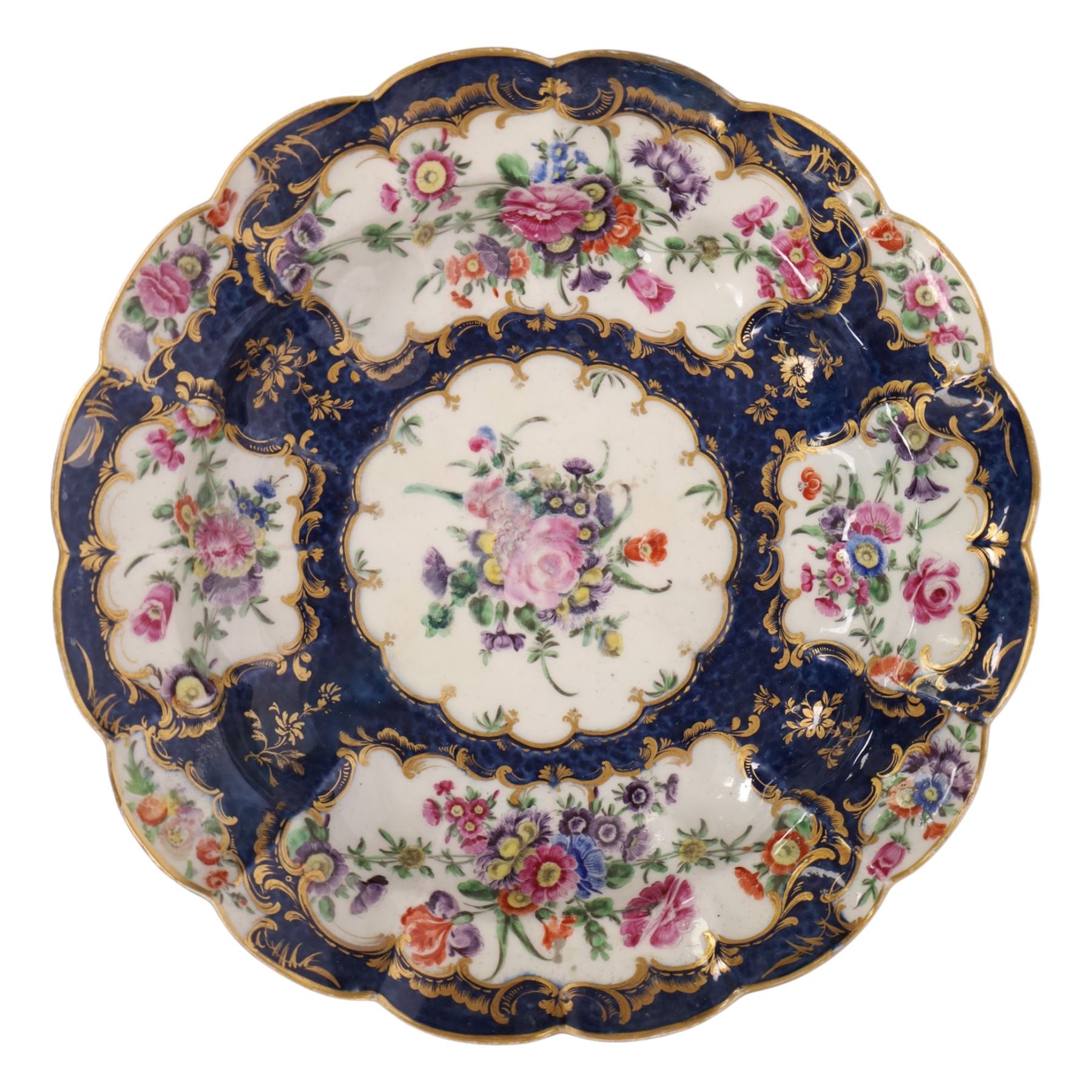 Pair of Worcester junket dishes, c1770, painted with panels of flowers on a blue scale ground within richly gilt rococo style borders and scalloped rim, hatched square mark to base, D24.5cm (2)
Notes: label suggests provenance relating to the Brownlow family of Belton House.