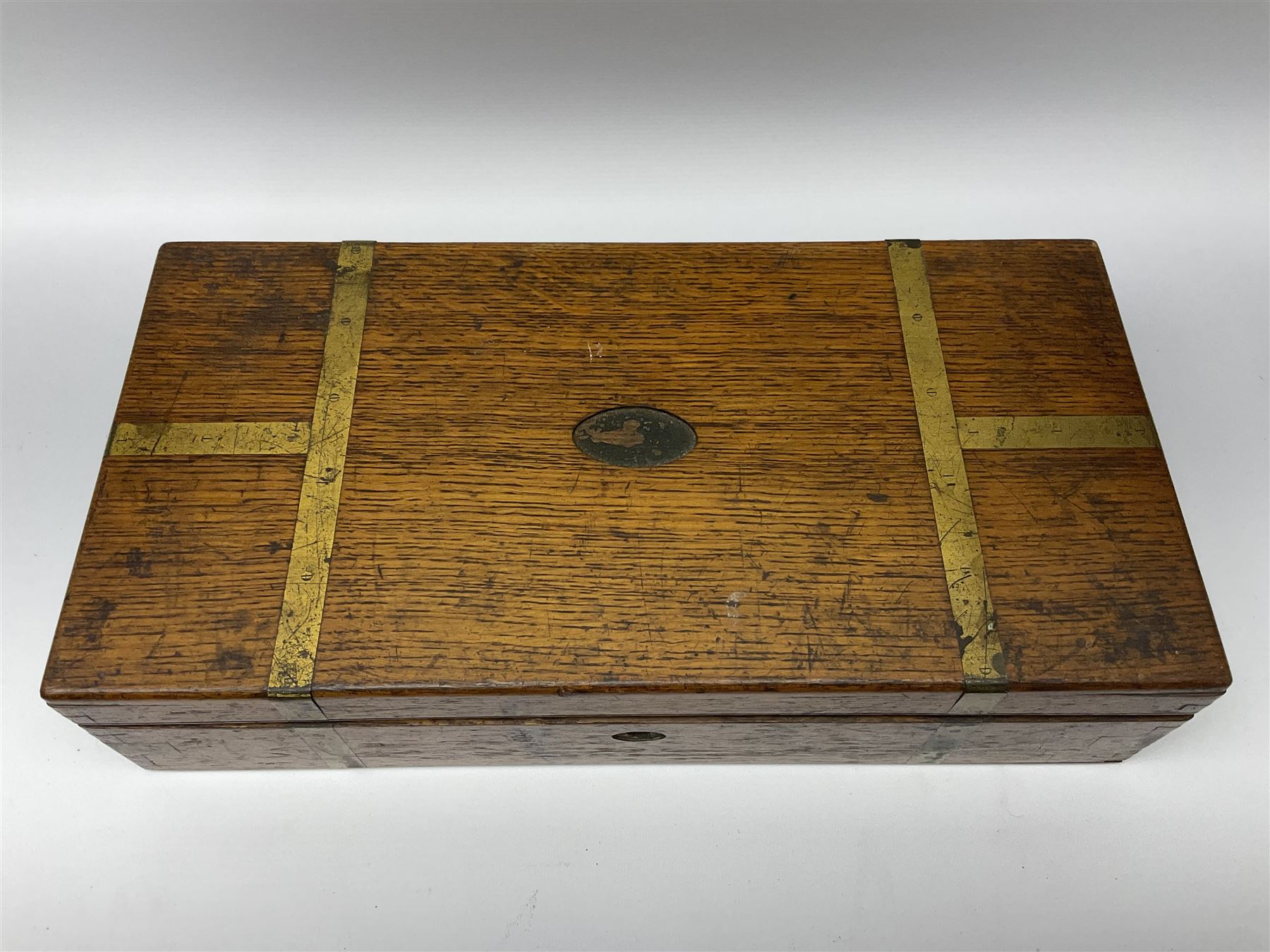 Naval doctor's surgical instruments, contained in a converted brass bound oak pistol box, the hinged lid opening to reveal two removable fitted trays, containing 19th century and later saws, scalpels, tweezers etc