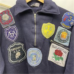 On the direct instructions of Anita Porter nee Lonsbrough Great British Olympic and Commonwealth Games gold medal winning swimmer - collection of early and international memorabilia comprising original Huddersfield Bath Club track suit top bearing eight stitched on cloth badges including British Empire & Commonwealth Games 1958 England Team, YSASA, North Eastern Counties ASA, ESSA Division 3,  English Schools Swimming Association winner etc
The swimming costume Anita wore at the 1958 Commonwealth Games in Cardiff, her first major championships, where she won two gold medals. The grey elastic on the sides, in those days, she would use to make it tighter and more streamlined.
Blue track suit from the 1960 Olympics which she wore on the podium receiving the gold medal.
1960 pool side towelling robe used at the Rome Olympics (interesting to note her name is spelt wrong on the embroidered label).
1962 Commonwealth Games pool side towelling robe used in Perth Australia when winning three Gold medals. 
It was also this year she became BBC Sports Personality of the year, the first female to do so.
Her 'lucky' pool side towel which she took with her to every event she competed in and which can be seen round her neck in many official celebratory photographs. Copies of some of these photographs are included for identification.
In addition there are two souvenir programmes of an evening event to honour Anita at The Theatre Royal Huddersfield and she has kindly signed the front cover on one of these.