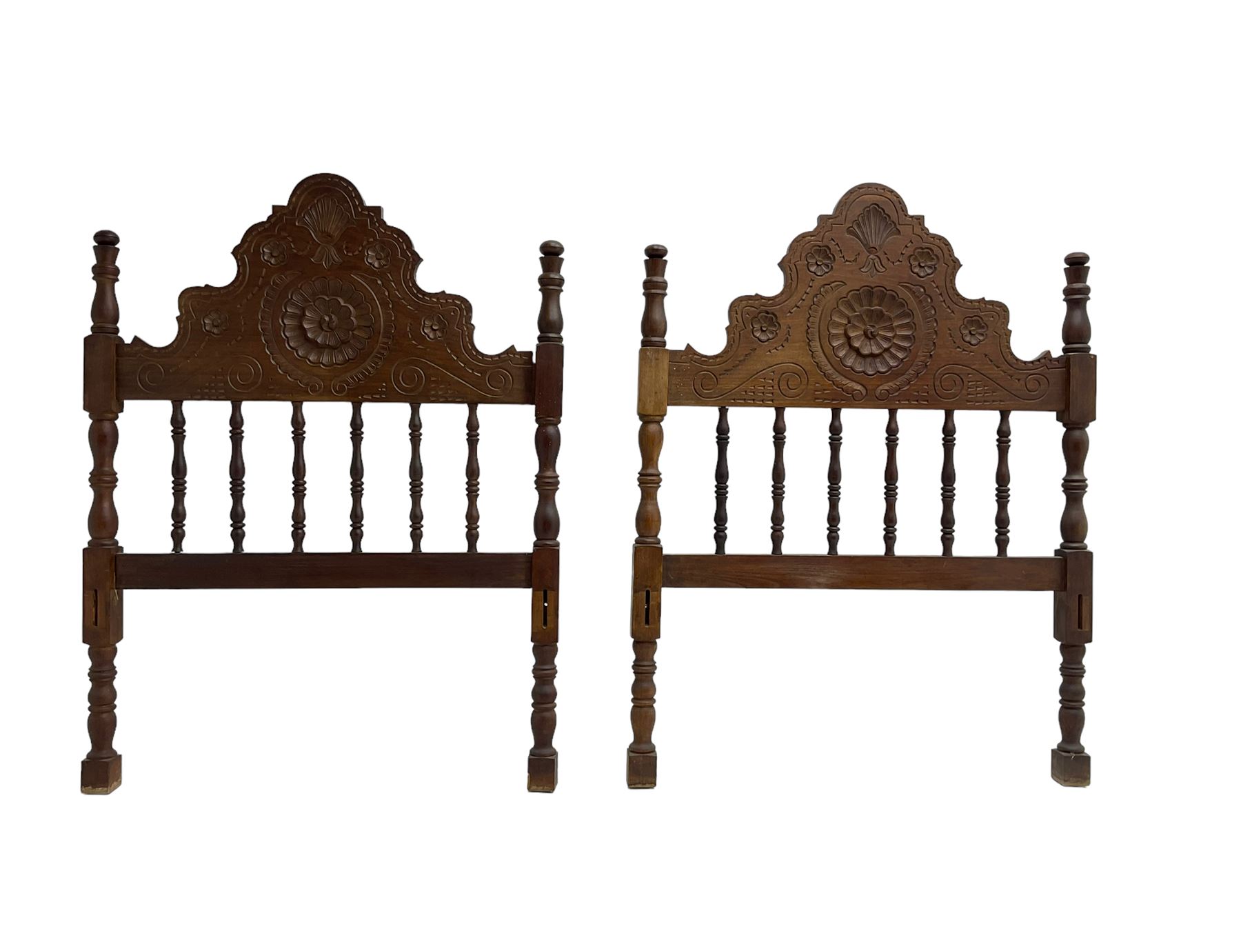 Pair Spanish stained beech single 3' bedsteads, spindle turned backs and carved with scrolling floral decoration 