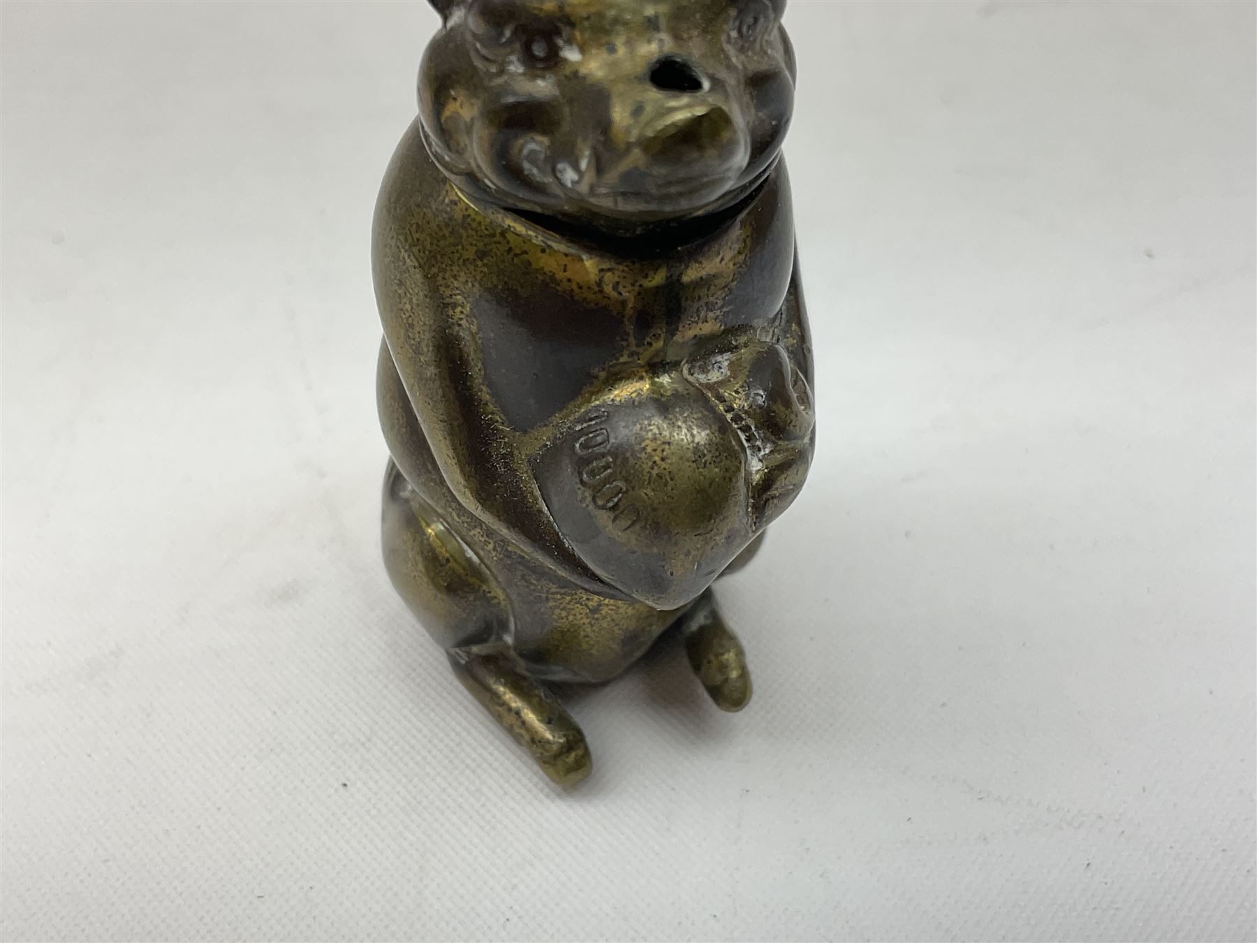 Victorian novelty brass vesta case modelled in the form of a pig holding a money bag, together with a silver vesta, hallmarked 