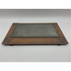 Arts and Crafts oak stand by Arthur Simpson of Kendal, of rectangular form with central hammered pewter panel, surrounded by a border with carved foliate corners, upon two bar supports, bearing label detailed 
