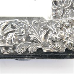 Edwardian silver mounted dressing table mirror, the bevelled mirror plate with silver surround embossed with flowers, C scrolls, putti and birds, with velvet easel support verso, hallmarked London 1903, maker's mark WC, probably for William Comyns & Sons, H33cm