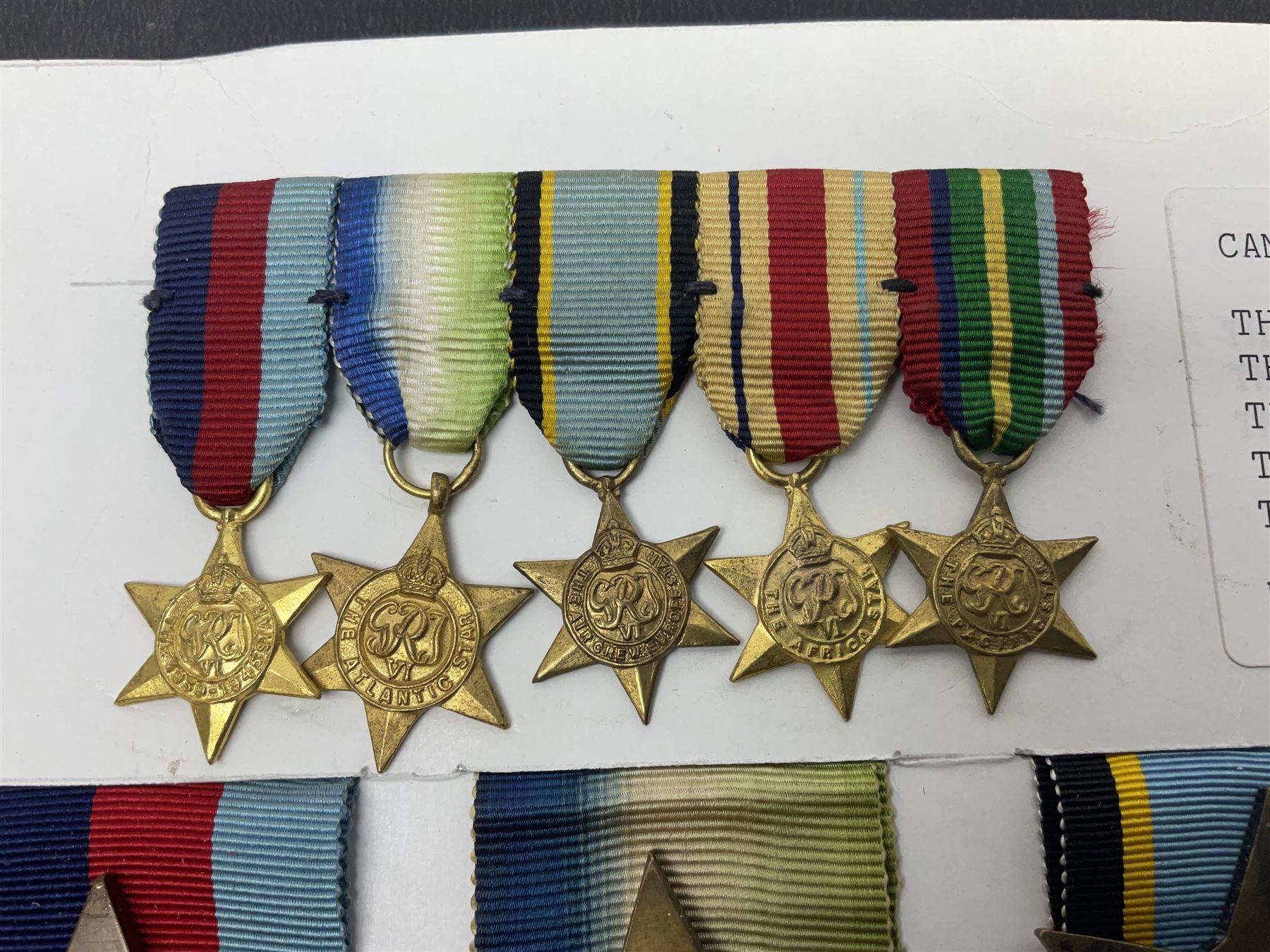 Representative display of WWII Campaign stars comprising 1939-1945 Star, Atlantic Star, Air-Crew Europe Star, Africa Star and Pacific Star; together with the corresponding group of miniatures; all with ribbons