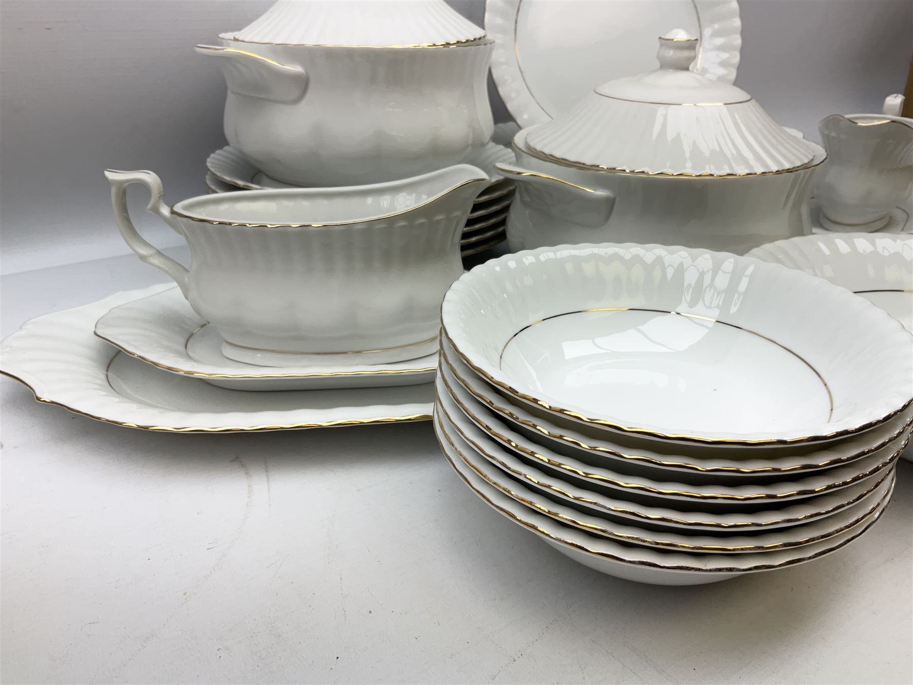 Chodziez Polish dinner wares decorated in white and gilt to include lidded twin handled tureens, bowls, plates etc