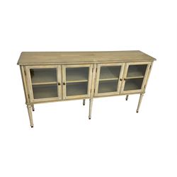 Washed finish sideboard or dresser, rectangular top over four glazed cupboard doors enclosing single shelf, raised on fluted tapered supports 