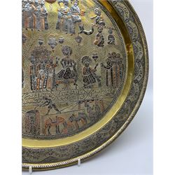 Early 20th century Cairoware charger, the brass dish of circular form with silver and copper inlay depicting a three tiered religious figural scene, within a script border, D42cm