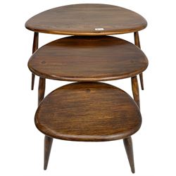 Ercol - mid-20th century stained elm and beech nest of three 'pebble' tables, raised on splayed supports