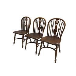 Set three late 20th century country oak Windsor chairs, hoop and stick back with pierced and fretwork work splat, dished seat on turned supports joined by crinoline stretcher 
