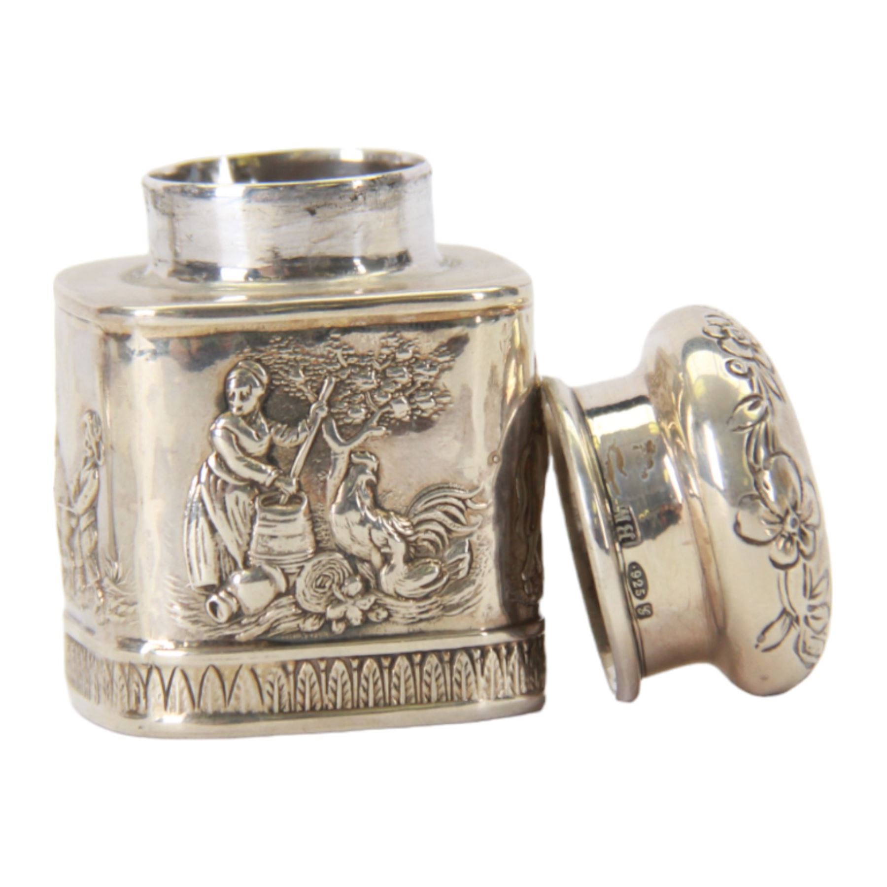 Late 19th century German Hanau silver miniature novelty scuttle, of cylindrical form with side handle and swing handle, the body impressed with figural genre scene, with Hanau marks for Karl Kurz, and hallmarked Samuel Boyce, Chester 1902, with 'F' foreign import mark, not including handle H3.5cm, together with a late 19th century German Hanau silver miniature novelty tea caddy, of rounded cube form, the body impressed with figures at work in a countryside setting, with Hanau marks for Neresheimer & Sohne, and hallmarked B Muller & Son, Chester import 1907, and marked 925, H5cm