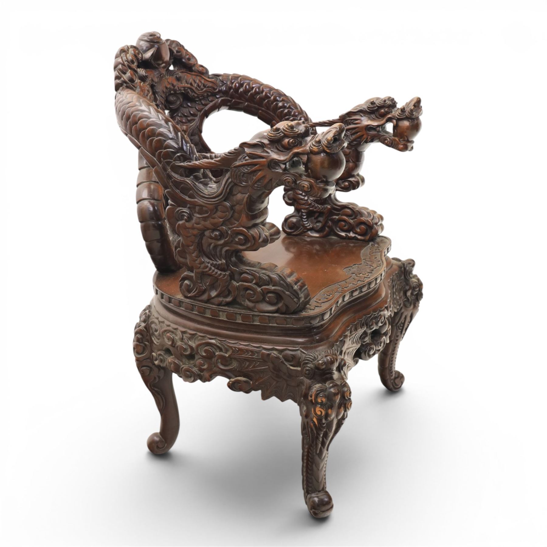 Chinese carved hardwood dragon throne chair, the shaped and pierced back with entwined dragons and cloud motifs, sweeping dragon-form arms terminating in carved heads, solid panel seat over foliate carved apron, on four mask carved cabriole supports