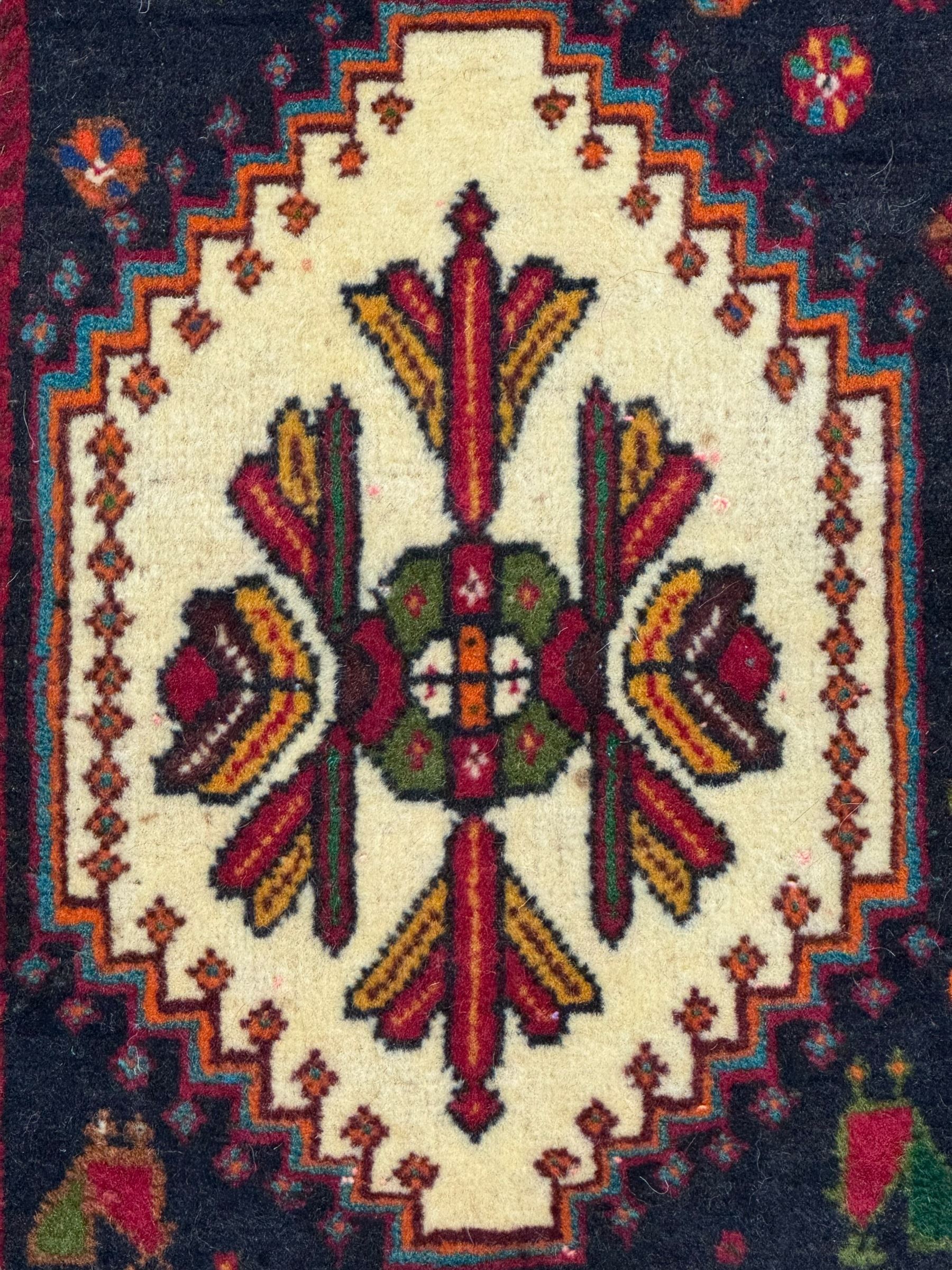 South West Persian Qashqai red ground runner, the crimson field decorated with three connected lozenges, surrounded by small stylised motifs of bird and plants, indigo spandrels with further stylised motifs, the border with repeating floral design 