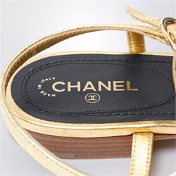 Chanel - pair of gold leather thong sandals, from the 2021 Summer Collection, the uppers centred with an interlocking gold tone CC motif in chain and leather, size 37C, unused with original dust bags