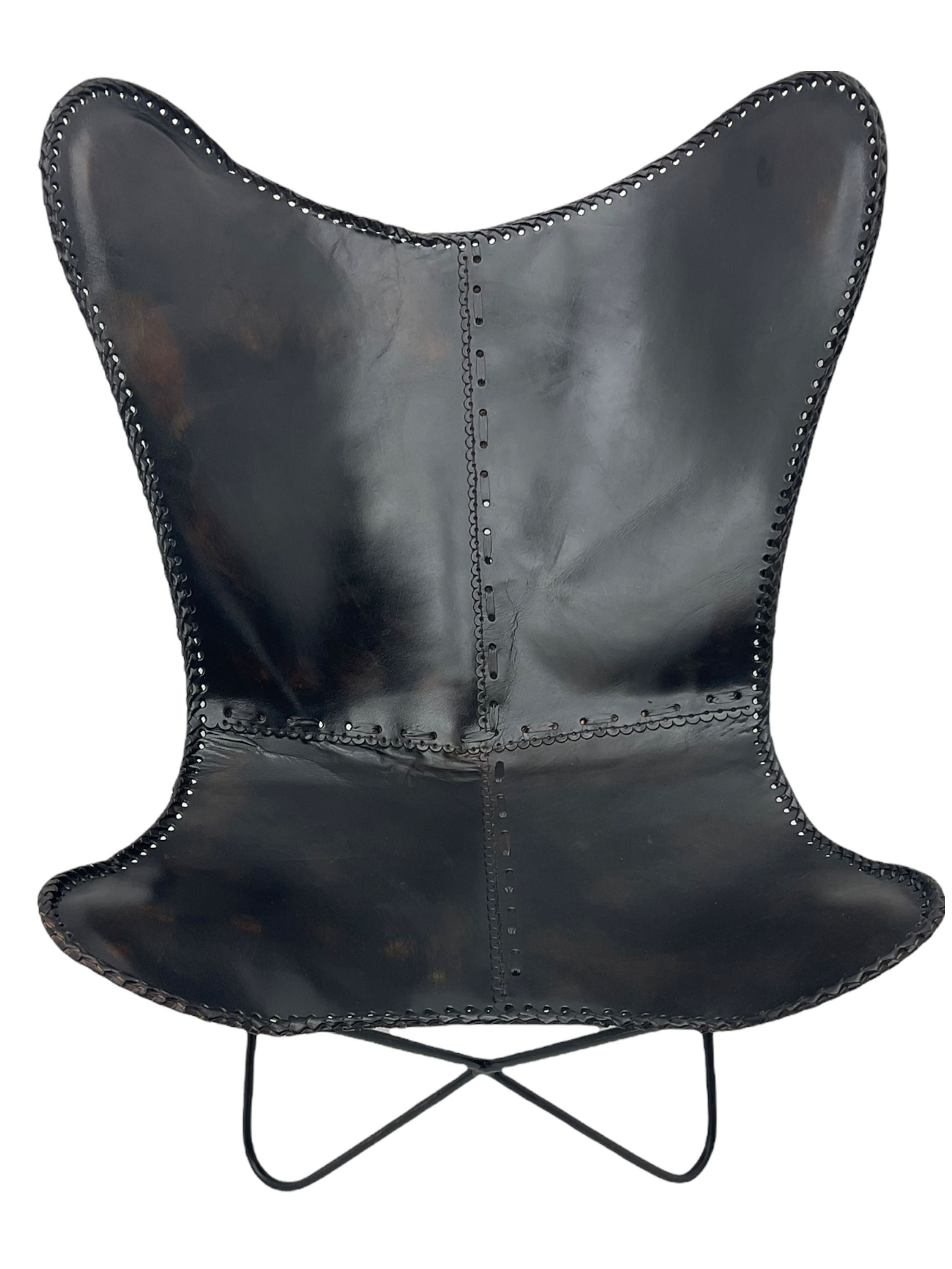 Metal framed butterfly chair upholstered in slung dark tan stitched leather 
